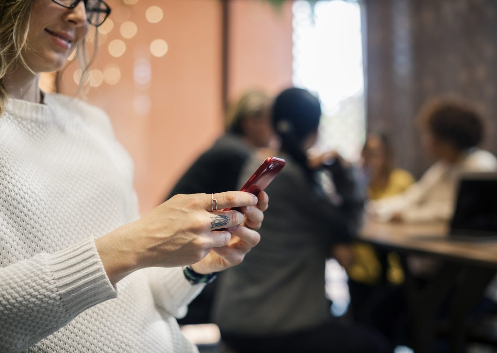 Femme sur son portable dialoguant avec un robot conversationnel