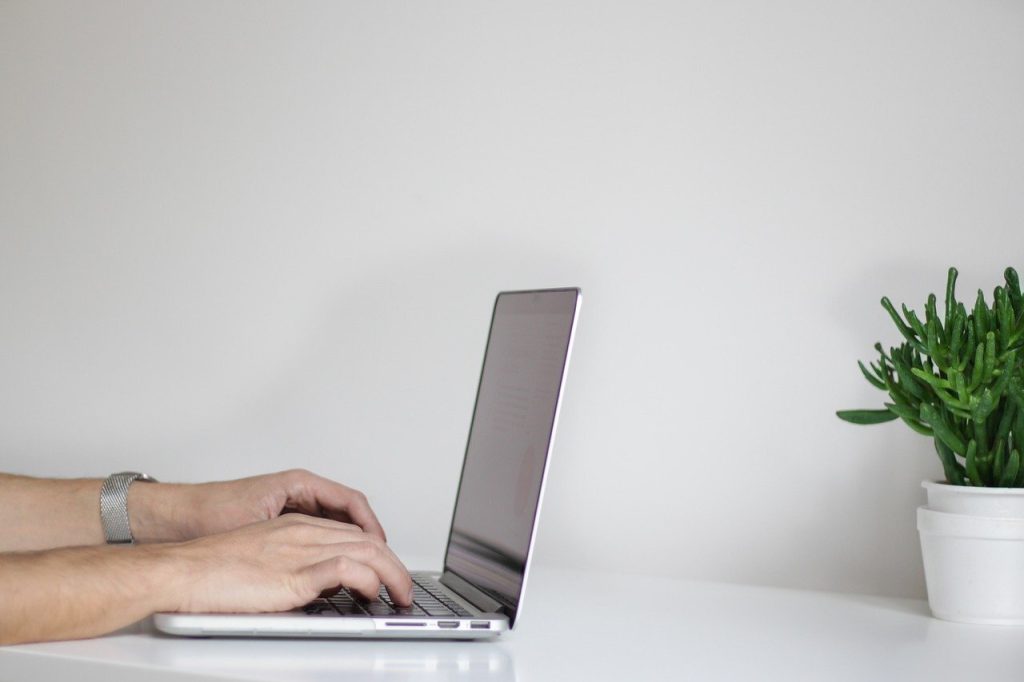 man typing on his computer keyboard